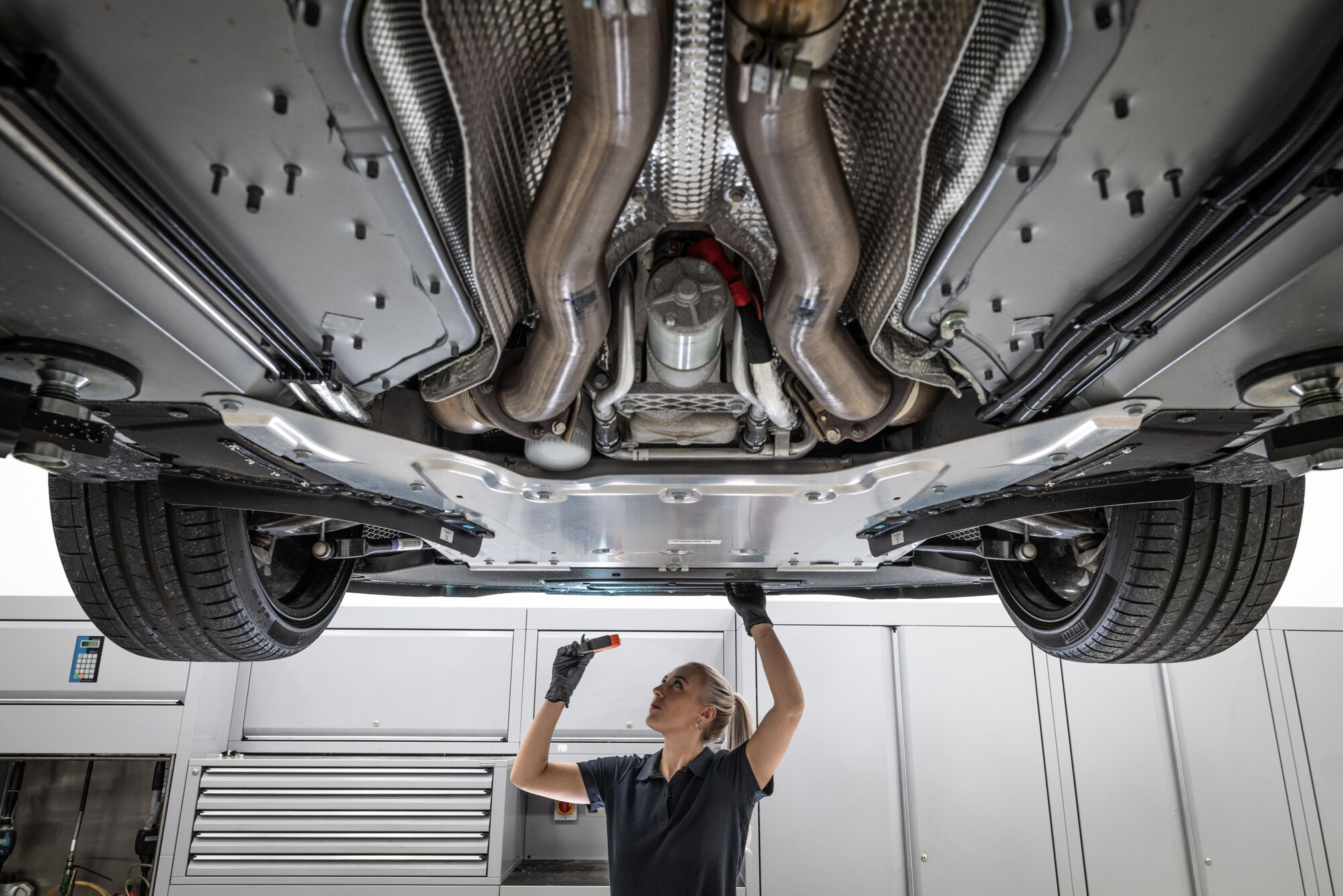 a woman repairing an Aston Martin car